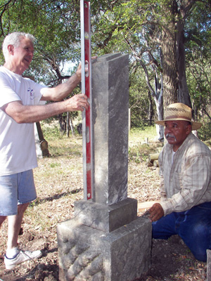 Two large, previously fallen Payne family tombstones were righted, another stone was leveled, and a loose footstone re-set in late June, 2009, at the cemetery. (L-R) Landowner Gene Herry helps HCHC worker Richard Gomez with the job.