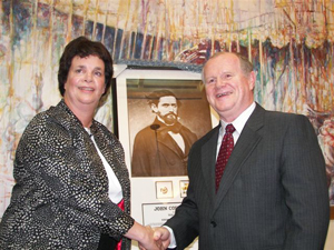 HCHC Chair Kate Johnson and San Francisco Sheriff Michael Hennessey share a happy moment and congratulatory handshake following the Texans' presentation to the sheriff of a framed photo of Jack C. Hays, complete with the representative badges Hays once wore with distinction.
